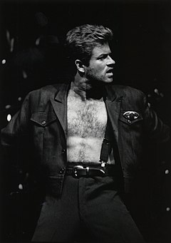 A man with an exposed chest performing onstage
