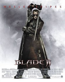 Blade standing opposite his opponent, wearing his traditional jet black special suit and sunglasses, wielding his Titanium made, acid edged sword, with a negative background image around him showing the face of an evil vampire. Near the bottom are the film's name, credits and billing details. Wesley Snipes' name is written on the bottom.