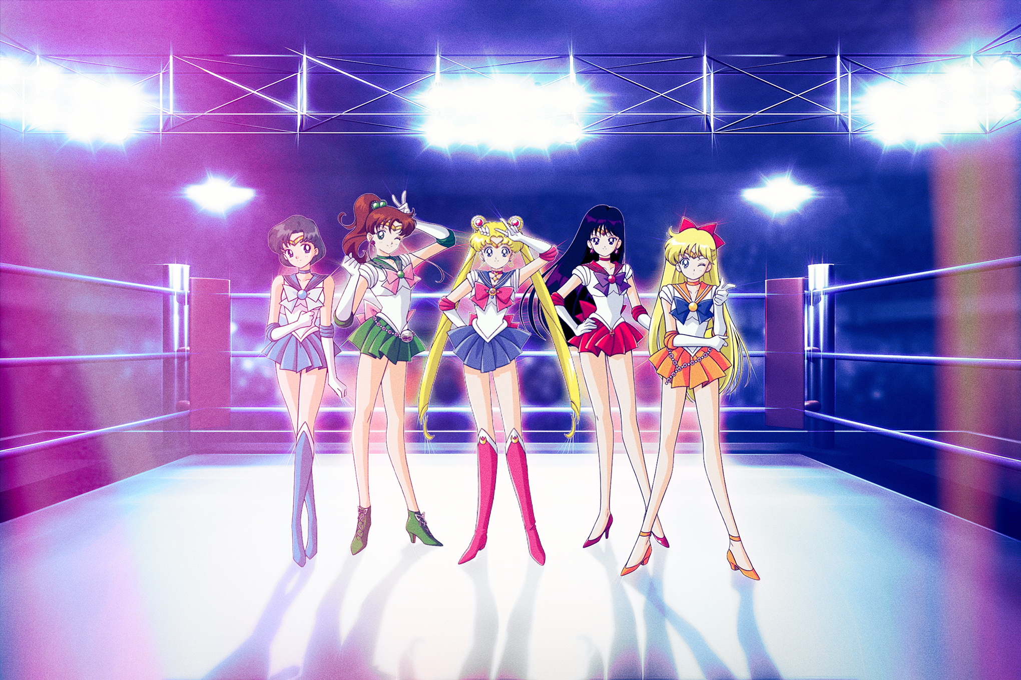 The Sailor Guardians from Sailor Moon standing in the middle of a wrestling ring illuminated by large floodlights.