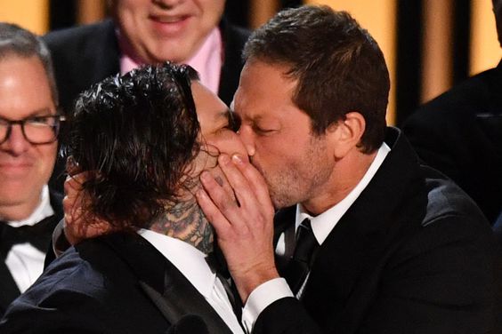 US actor Ebon Moss-Bachrach (R) kisses Canadian chef and actor Matty Matheson as the cast and crew of "The Bear" accept the award for Outstanding Comedy Series onstage during the 75th Emmy Awards at the Peacock Theatre at L.A. Live in Los Angeles on January 15, 2024.